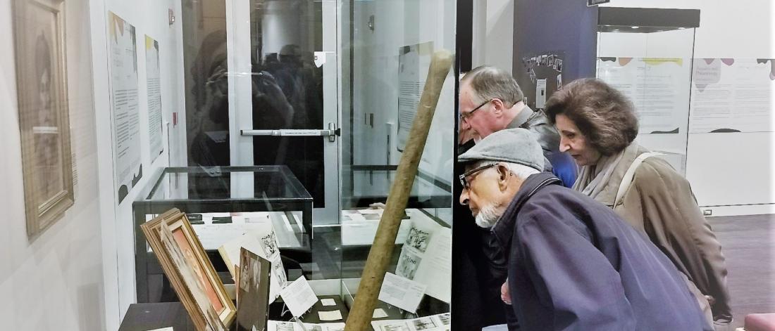 Three people look into a showcase at the museum 