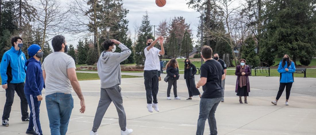 Group of youth playing a casual game of outdoor basketball