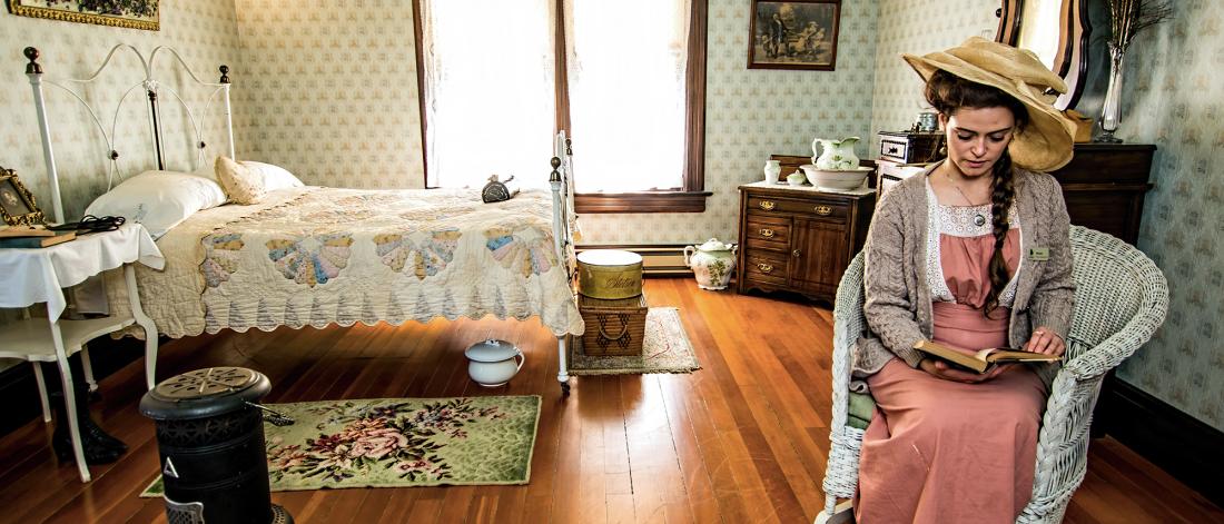 Woman sitting in master bedroom in Historic Stewart Farm House