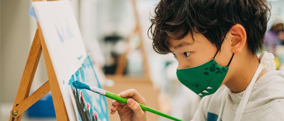 Child painting a on a canvas