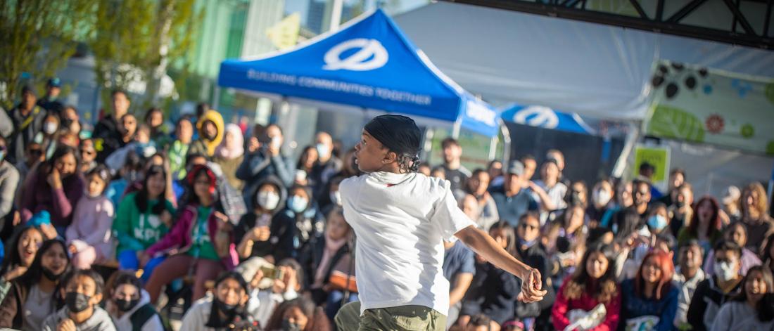 a youth dancing with a crowd cheering them on