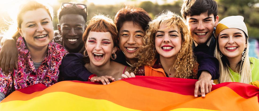 A group of youth with the Pride flag.