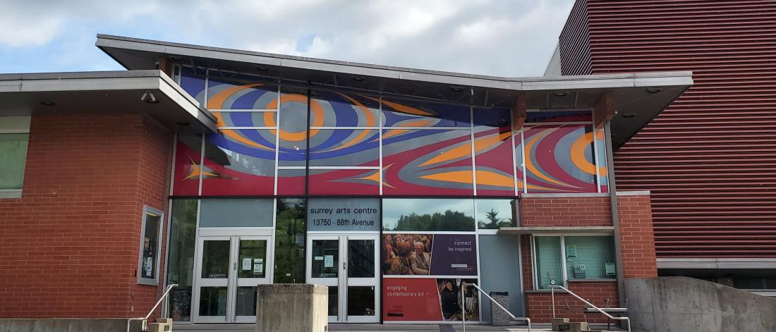 A photo of Surrey Arts Centre with a mural on its front windows.