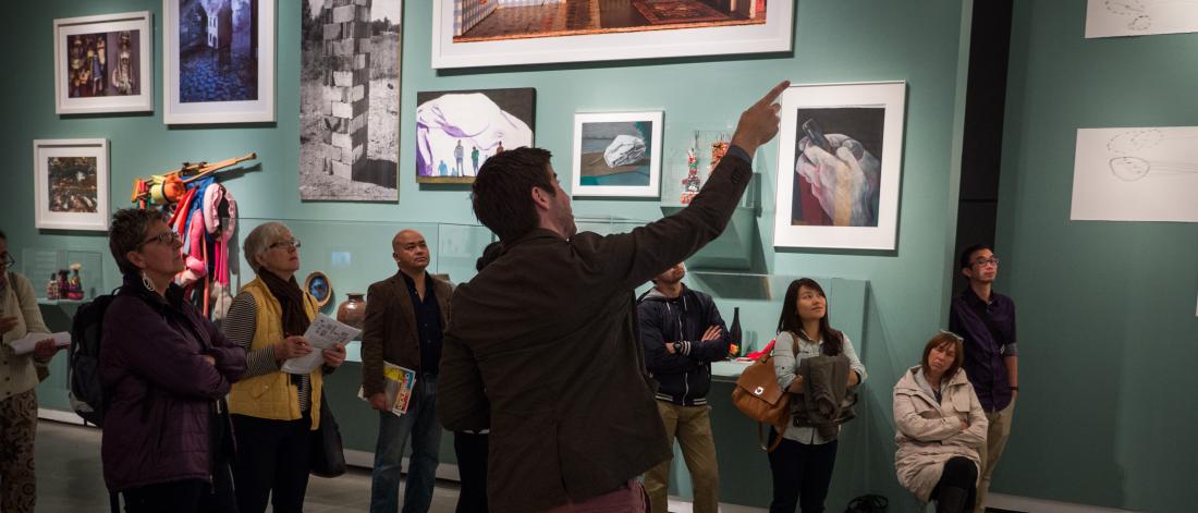 Curator Jordan Strom leads group of people on an exhibition tour in Surrey Art Gallery.