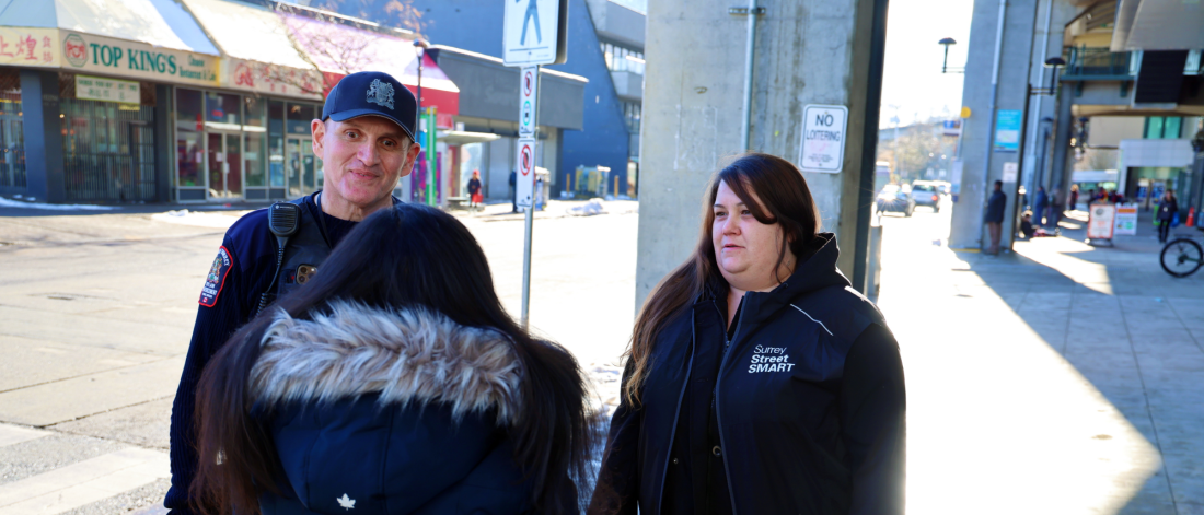 two outreach workers speak to another person