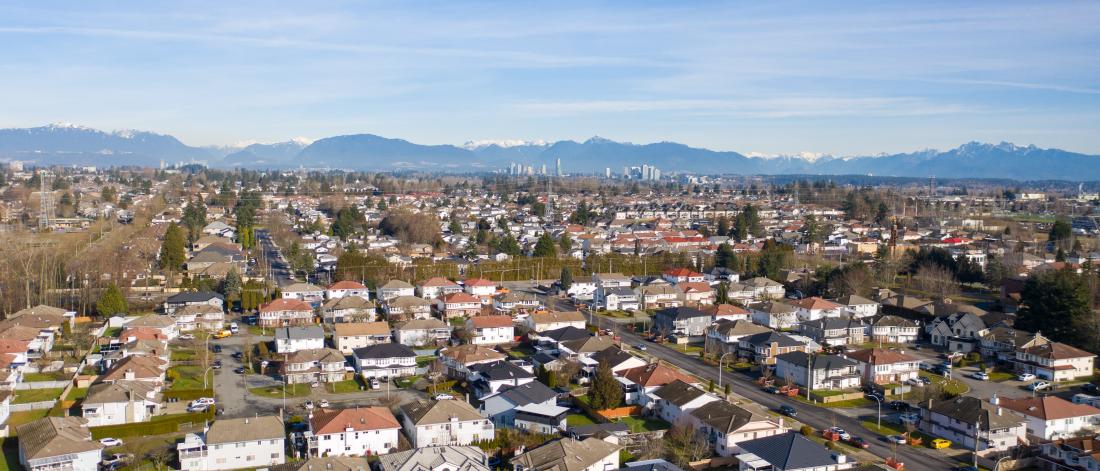 aerial view of residential houses in Surrey with mountains in the background