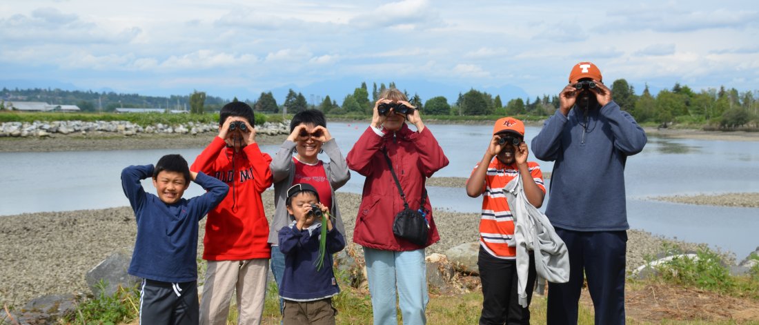 family with binoculars at park