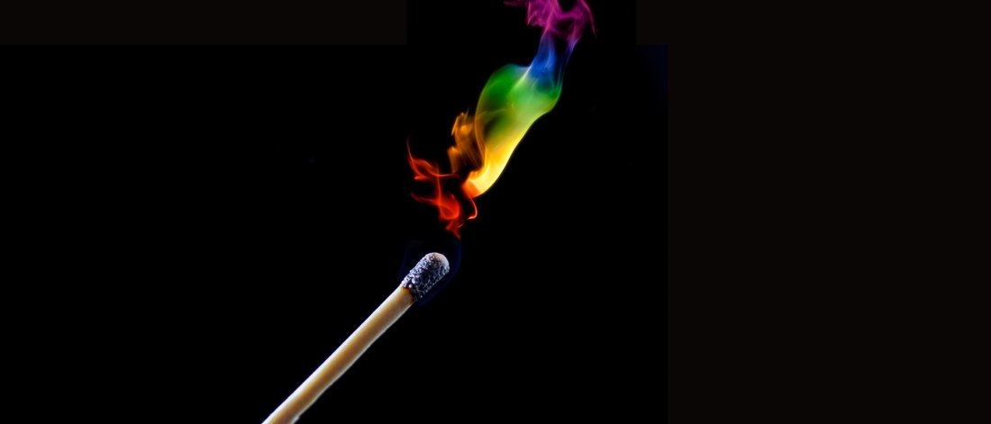 A match burns with a rainbow flame
