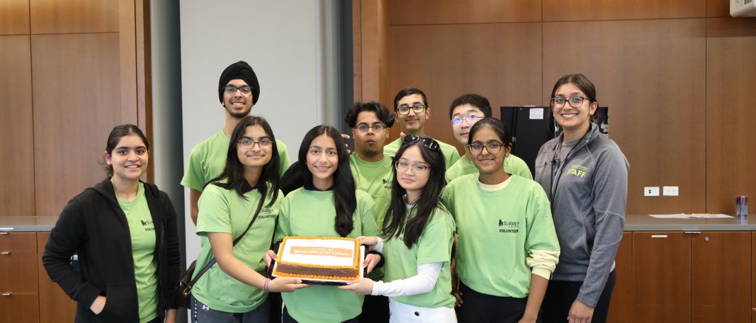 Group photo of Surrey's Leadership Youth Council holding a cake