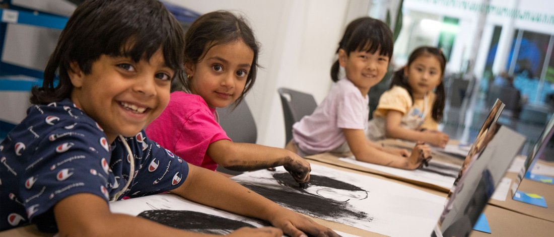 Smiling children sitting together in a drawing class