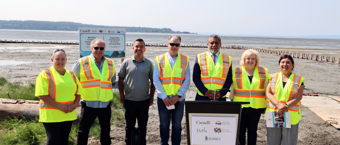 dignitaries stand in front of the living dyke at mud bay