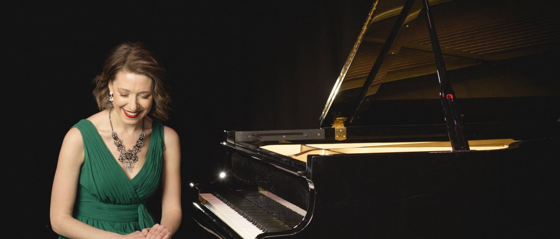 Sarah Hagen sits at a grand piano