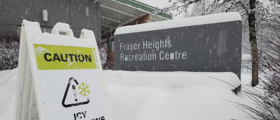 Fraser Heights Rec Centre with snow and sign that says 'caution icy conditions'