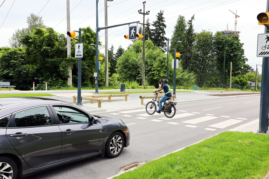 A cyclist crossing the road with a car stopped