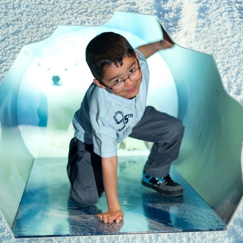 A boy makes his way through an ice cave