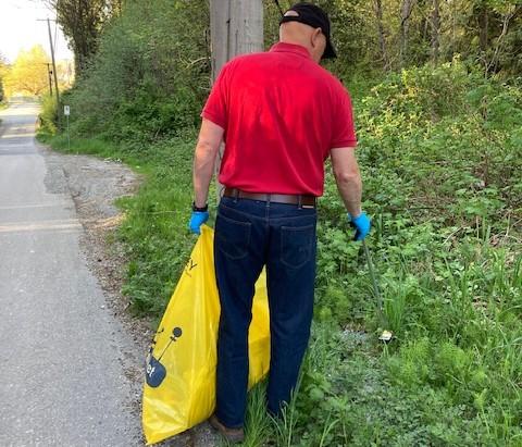 Man in red t-shirt with yellow trash bag