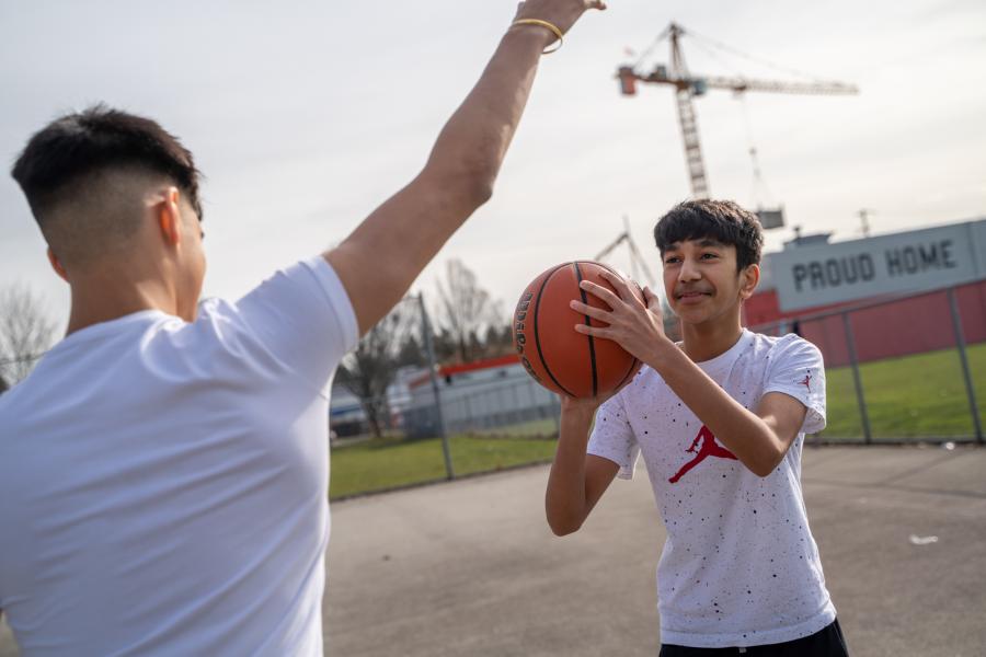 Two young people playign basketball at Tom Binnie Park.