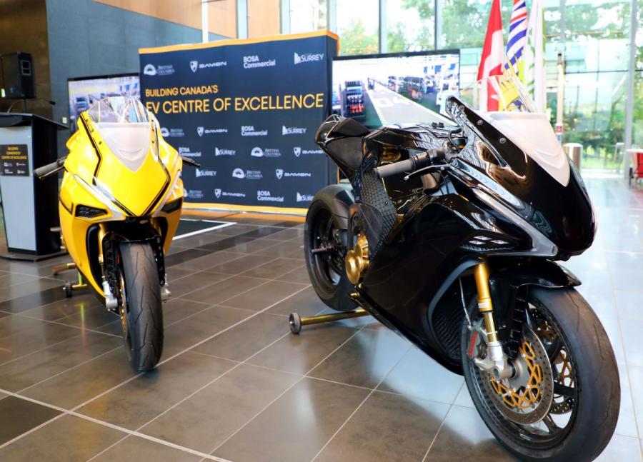 A yellow and a black motorcycle indoors