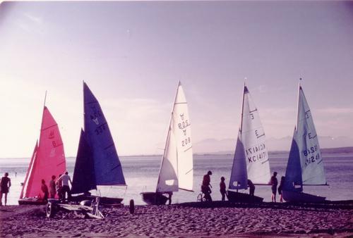 Six sailboats on a shoreline in the 1970s