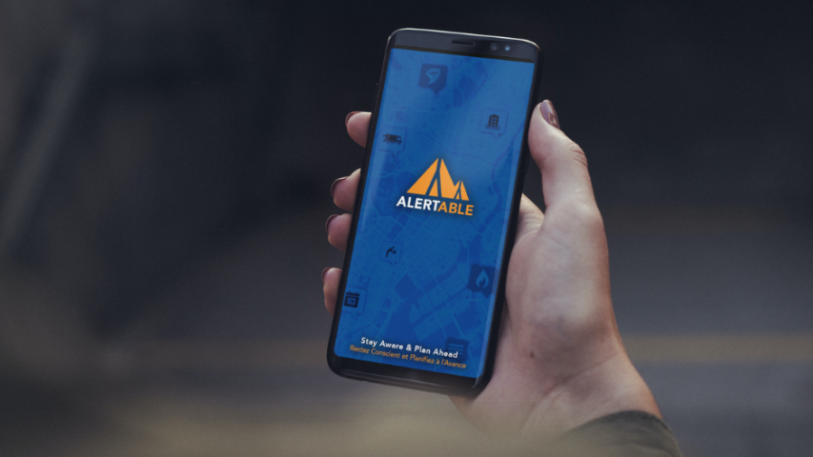 hand holding phone with alertable logo
