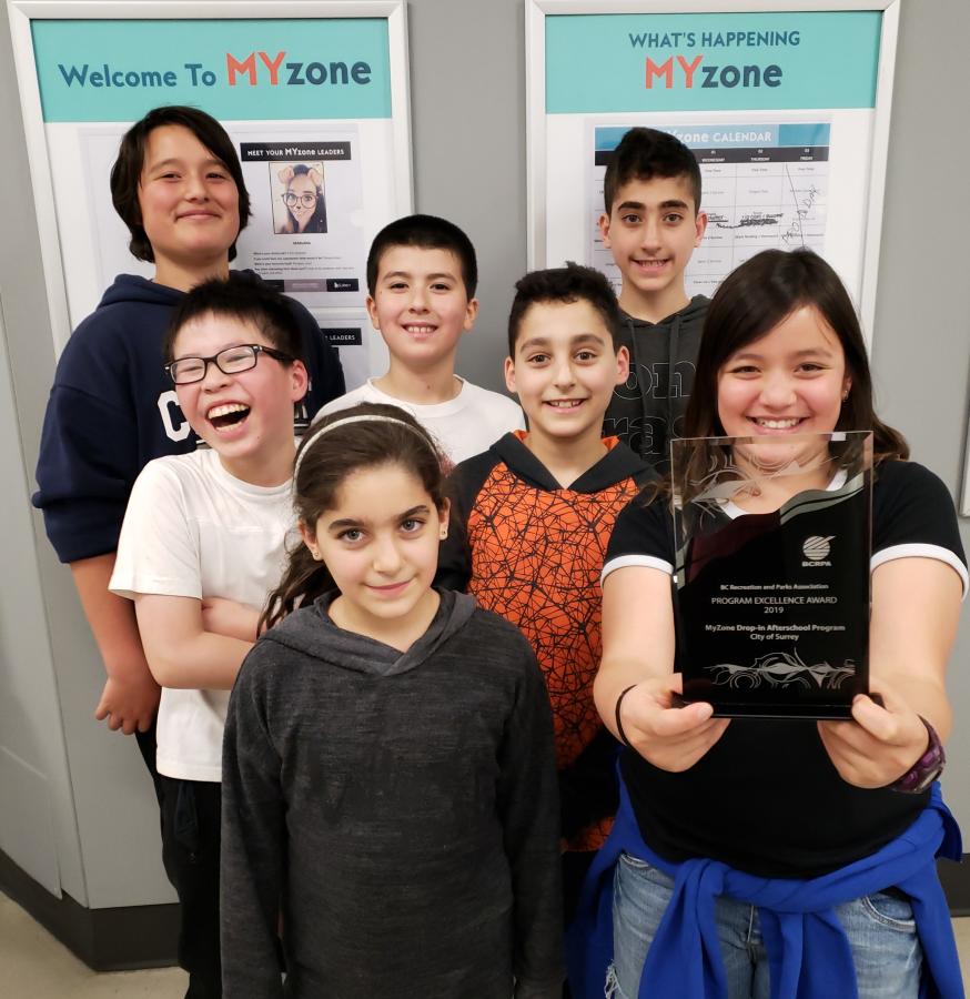 A group of children holding the Program Excellence Award for MYzone. 