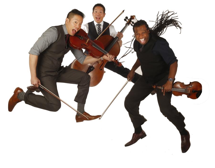 three performers from jumping in the air holding their instruments