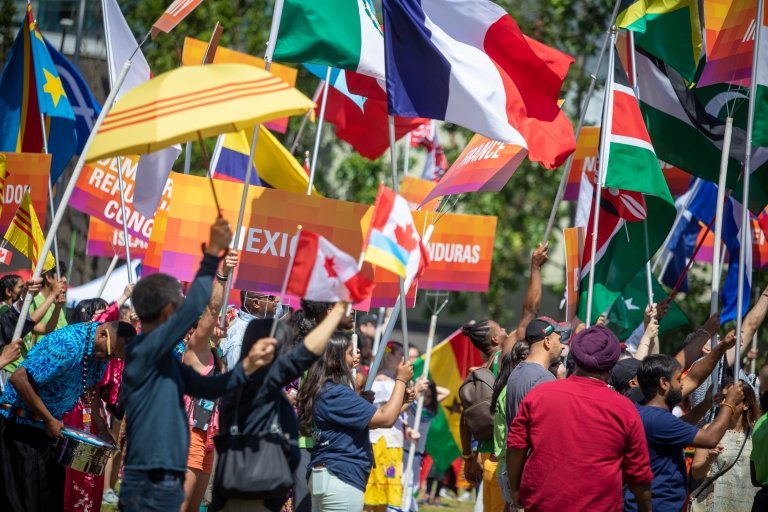 Participants waving colourful flags attending the Parade of Culture