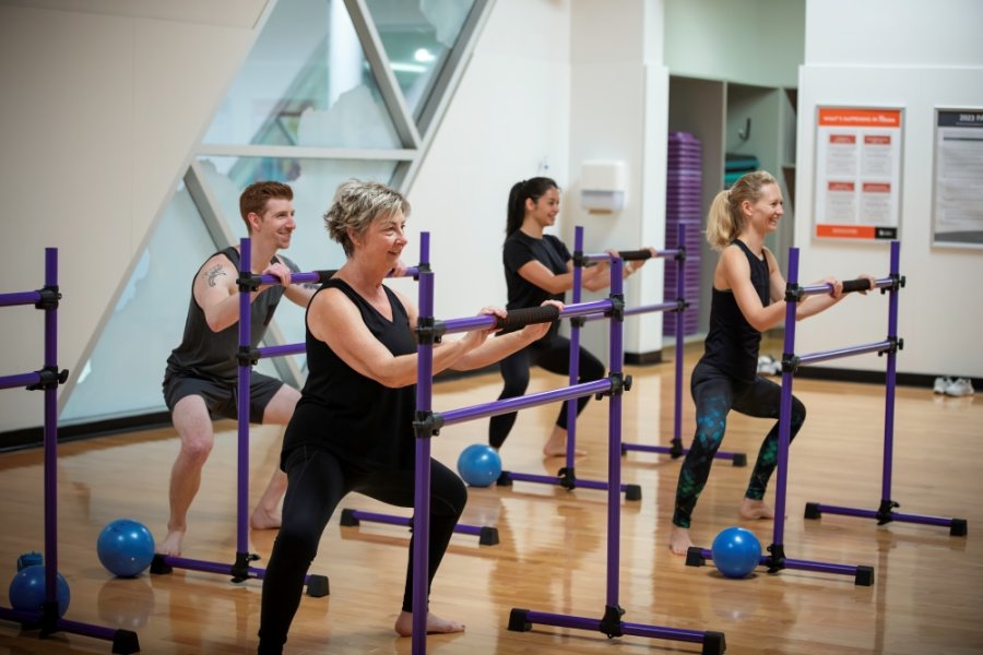 People squatting in a Barre class.