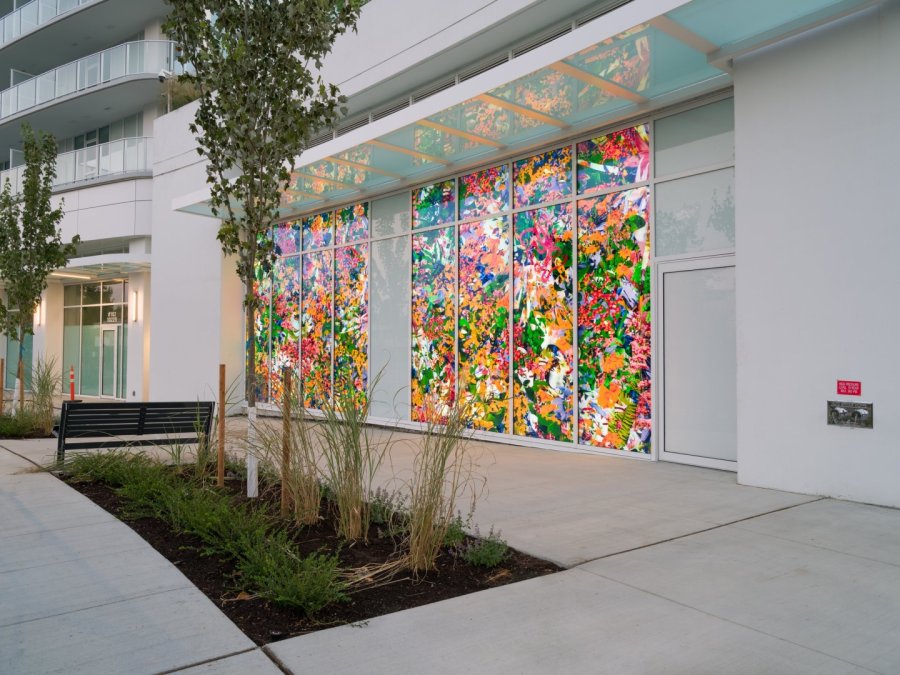  A brightly lit floral art installation on an urban building window.