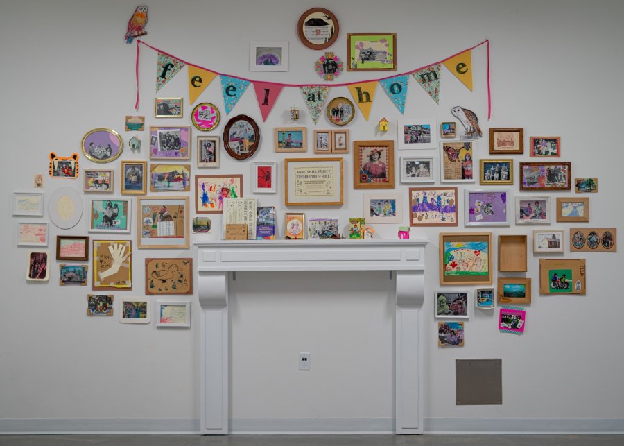 Showcase of images that community members collaged and remixed, presented on a wall above a fireplace mantel