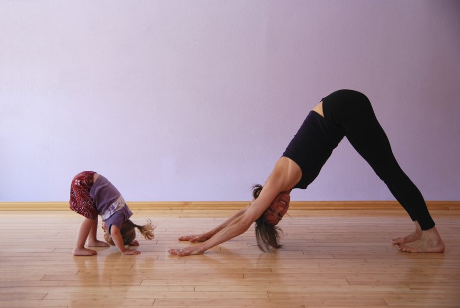 A mom and her child doing yoga.