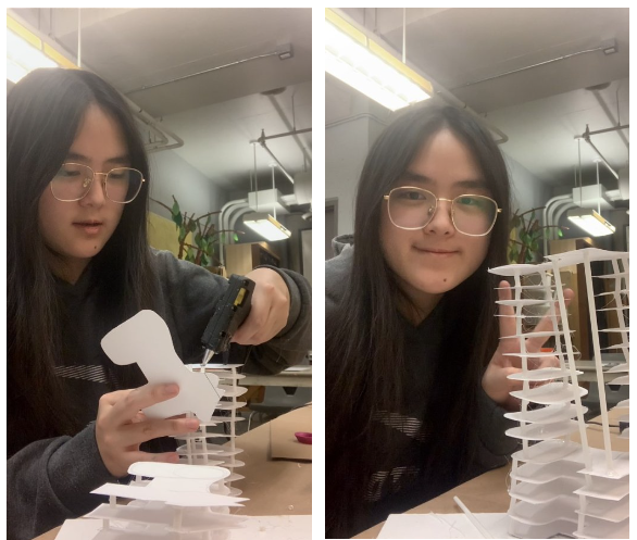 A focused individual works on assembling a white structure with a glue gun.