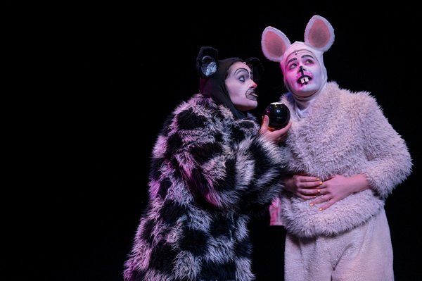 one actor wears a black and white rat costume and holds a magic 8-ball, the other actor's rat costume is white 